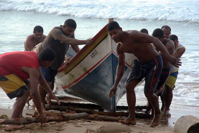 Fischer, die ihren Hafer an einem Strand in Venezuela ziehen 